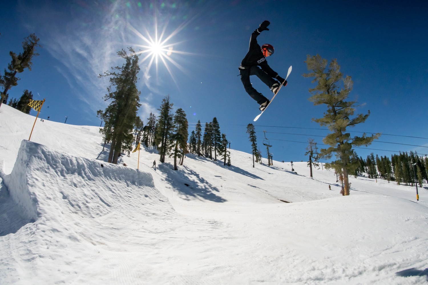 Devo snowboarder doing a grab off a jump